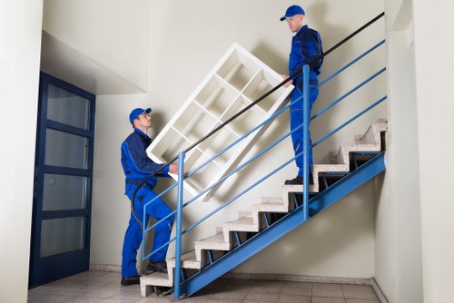 Moving crew wearing PPE while lifting boxes and furniture