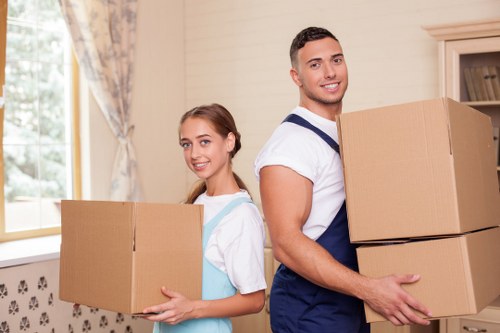 Mover carrying furniture in a Streatham flat with stair access